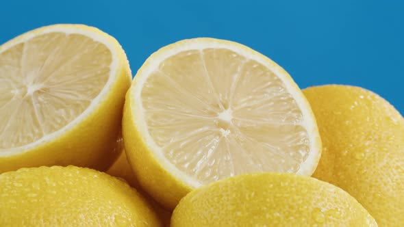 Lemons Isolated on Blue Background Pouring Water on Fresh and Ripe Citrus Fruits