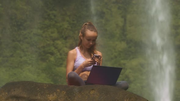 Woman with Computer Reads Text Messages on Stone