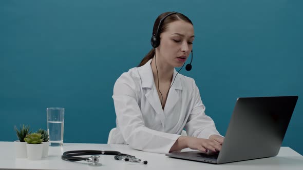 Sexy Female Doctor in a Medical White Coat Advises Patients Online. Isolated