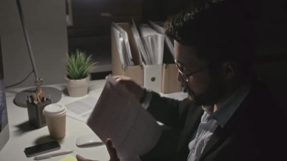 Man Finishing Financial Report at Night