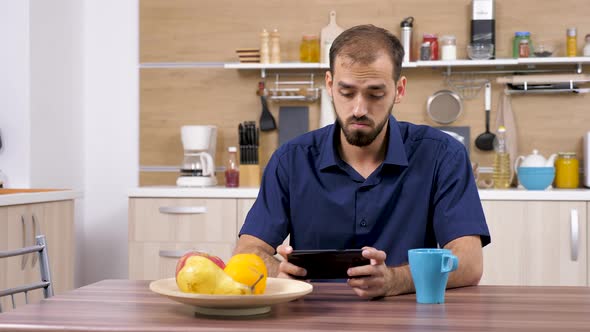 Man Using a Smartphone in the Kitchen