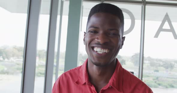 Portrait of laughing african american creative businessman in modern office interior