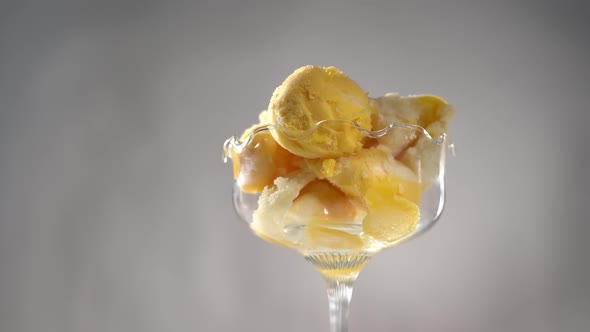 Close Up of Yellow Fruit Ice Cream Scoops in a Glass Cup