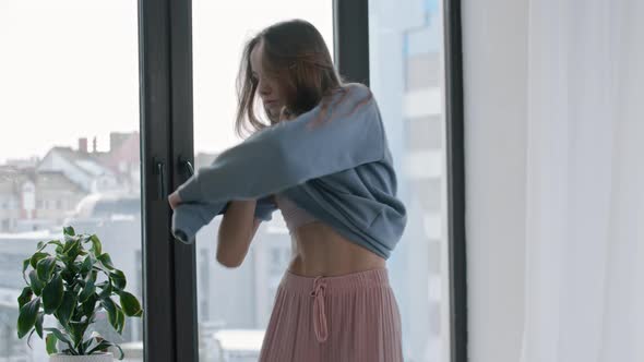 Young Woman Dancing and Taking Off Her Sweater