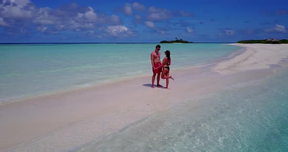 Young lady and man on honeymoon vacation enjoy life on beach on paradise white sand background 