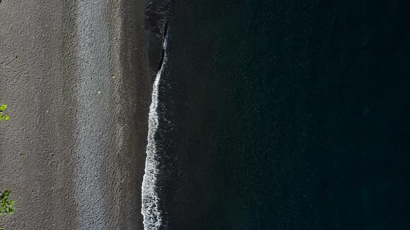 Top Down View on Waves on Black Sand Beach