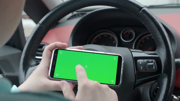 a man in a car holding a phone green screen