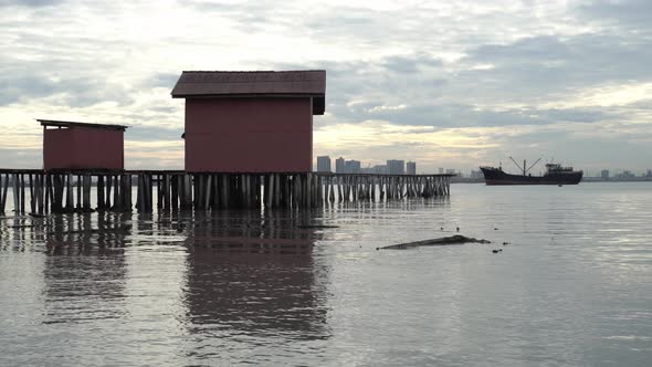 Old red wooden temple on bridge at Tan Jetty