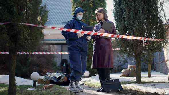 Wide Shot Serious Confident Female Criminalist and Detective Talking Standing in Sunlight on Crime