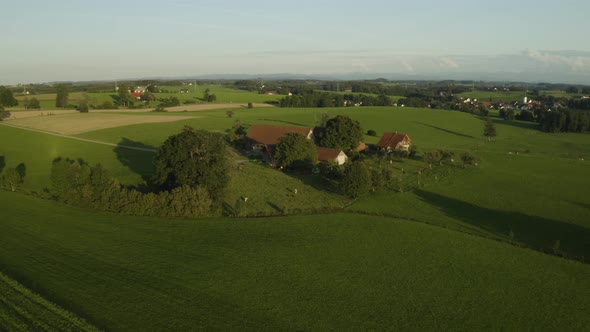 Aerial establishing shot of rural farm set in green fields in central Europe