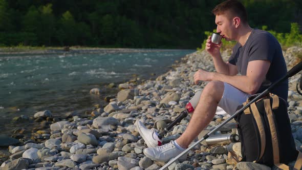 Handicapped Hiker Drinking Tea on Rocky River Bank