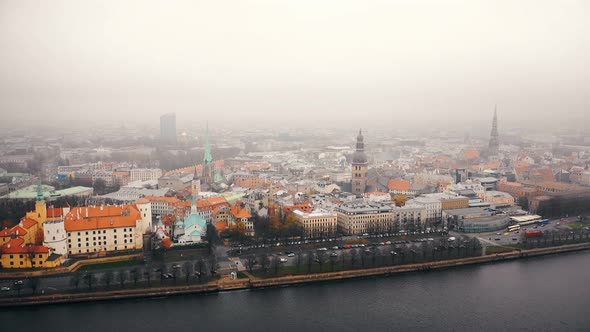 Beautiful Aerial Skyline Panorama of Riga Old Town, Car Traffic Moves Along Daugava River Under Fog