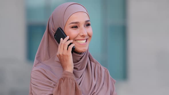 Arabian Young Happy Emotional Woman in Headscarf Standing in City Talking Cellphone Smartphone