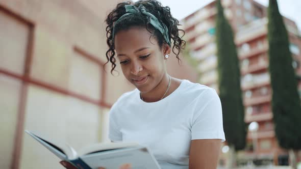 Smiling brunette African woman reading book