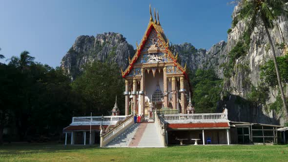 Ancient Traditional Buddhist Temple Wat Khao Daeng, Surrounded By Limestone Cliffs and a Rainforest