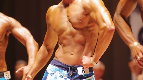 Professional Bodybuilders Posing on Stage at Athletic Competition, Sports