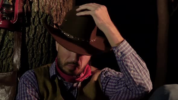 Cowboy Prepares To Sleep in the Woods at Night