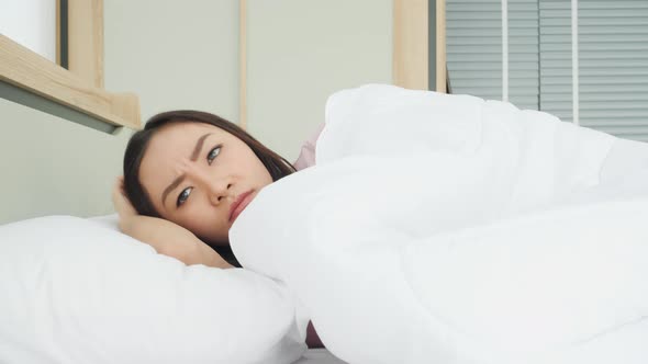 Woman waking up and irritated from noisy in bedroom