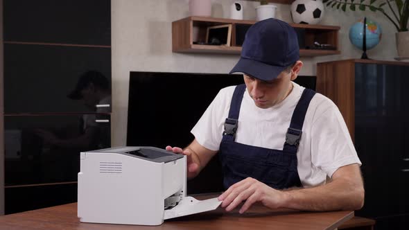 Repairman with Screwdriver Fixing Modern Printer in Office