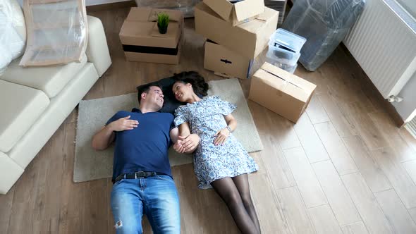 Top View Couple Lying Down on the Floor of Their New House