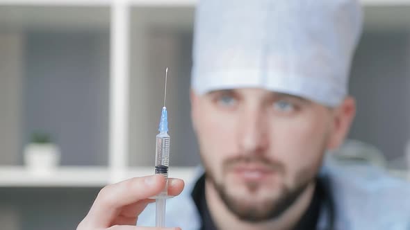 Doctor Is Preparing for the Injection. Doctor Holds the Syringe in His Hand and Presses the Valve To