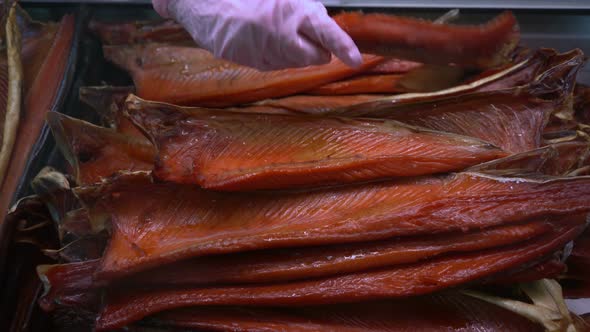 Hand Showing Smoked Salted Red Salmon on Counter at Fish Market