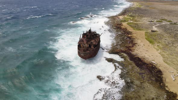 Aerial orbit over a shipwreck standing on the shore of the Klein Curacao island in the Caribbean