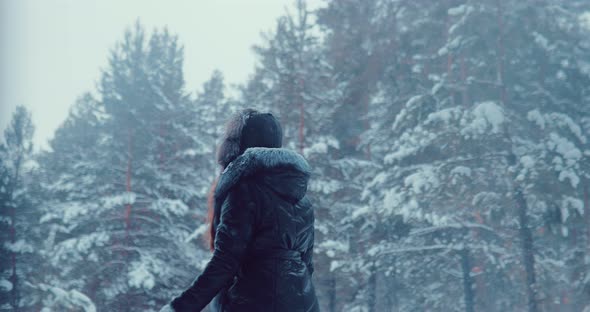 Woman Walks Through the Woods in Winter