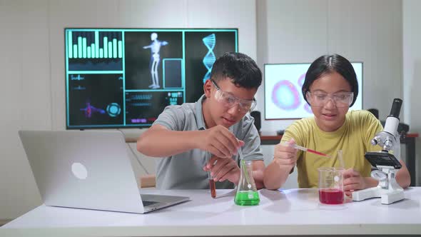 Excited Young Asian Boy And Girl Learning Science Experiment In Laboratory At Classroom