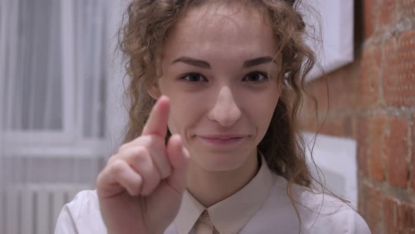 Serious Female Pointing at Camera with Finger