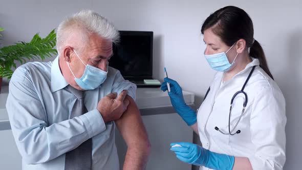 Doctor Vaccinating Senior Man