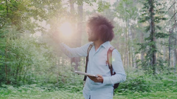 Ecologist or Biologist Worker with Tablet PC Hiking in Forest