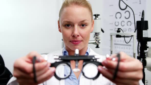 Smiling female optometrist holding messbrille