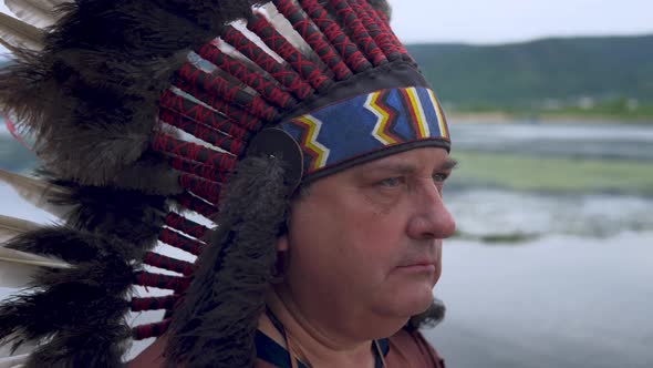 Old Native American Indians Looks Into the Sunset. Background of the River. Clouse Up