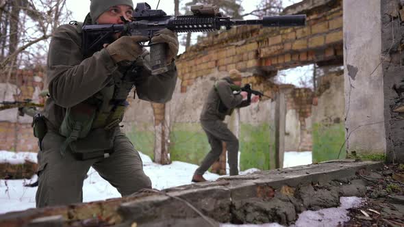 Group of Young Armed Men and Women Walking in Slow Motion Aiming Hiding in Ruined Building alt