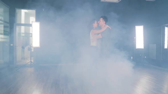 A Couple Dances in a Dance Studio Filled with Smoke