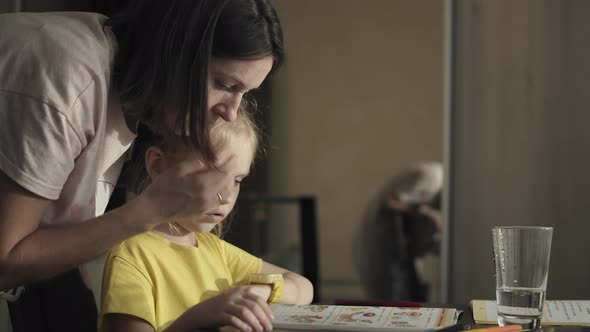 Little girl doing homework with her mother at home