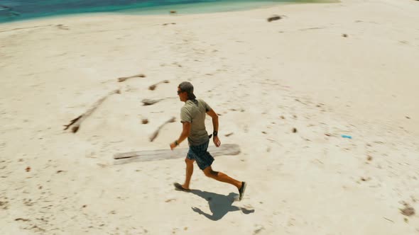 Man Runs on a Sandy Beach on Vacation