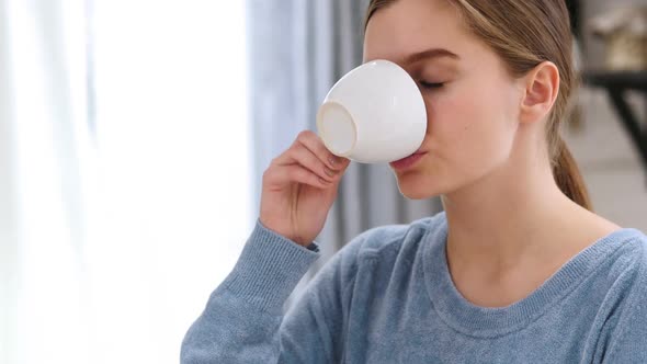 Relaxing Beautiful Woman Drinking Coffee at Home