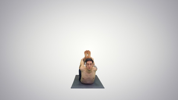 Shirtless Athletic Man Demonstrates a Yoga Bow Pose On