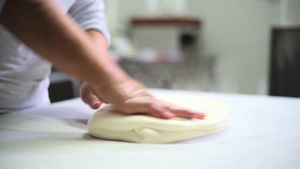 Female worker forming warm cheese in cheese factory