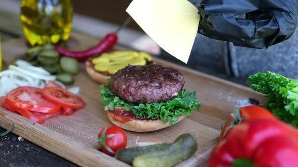 Making Burger  Putting Slice of Cheddar Cheese on a Cutlet