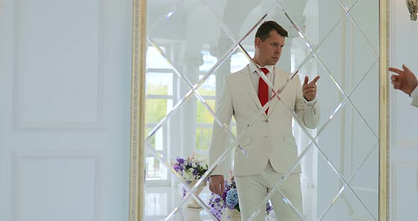 Groom Looks in the Mirror  Businessman Looks at His Reflection in the Mirror