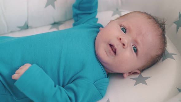 Upset Baby Lies Bothering Little Legs in Comfortable Cocoon