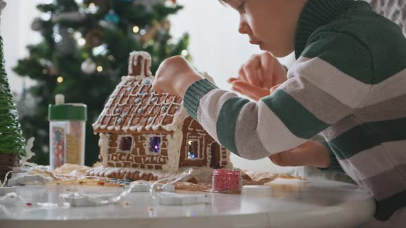 Little Boy with Mother Decorating Christmas Gingerbread House Together Family Activities and