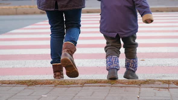 Mom and Child Cross the Road at the Zebra Crossing