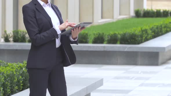 Elegant Blonde Business Woman with Tablet Computer Near Office Building