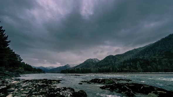 Time Lapse Shot of a River Near Mountain Forest. Huge Rocks and Fast Clouds Movenings.