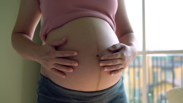 Happy Pregnant Woman and Expecting Baby at Home