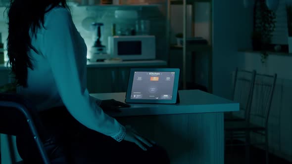 Woman Looking at Tablet in House with Automation Lighting System